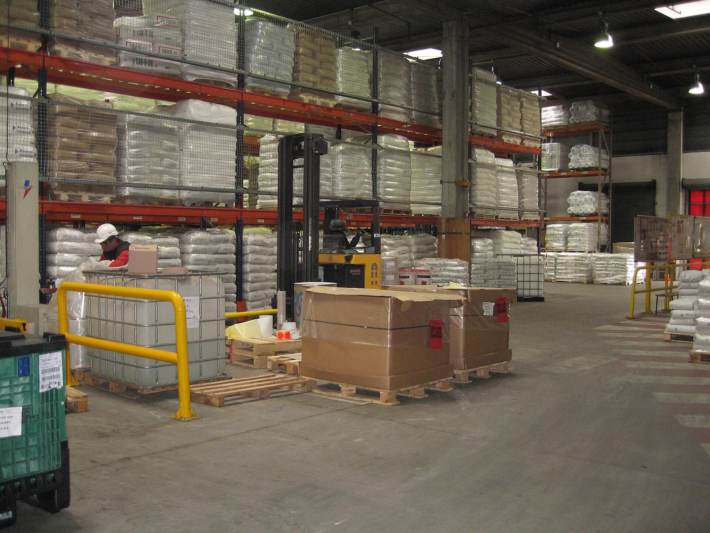 Wrapped pallets and carton stacks inside an industrial warehouse